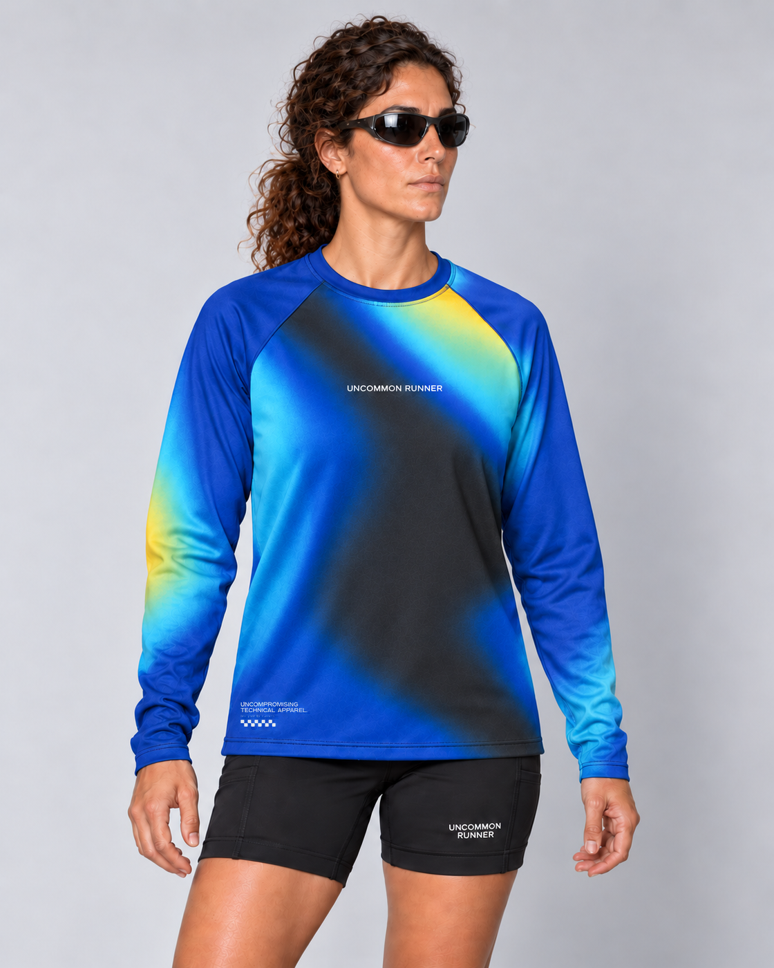 Front studio view of a female model wearing the Entering Flow State long-sleeve TempoTech running tee with black Shift-5 shorts