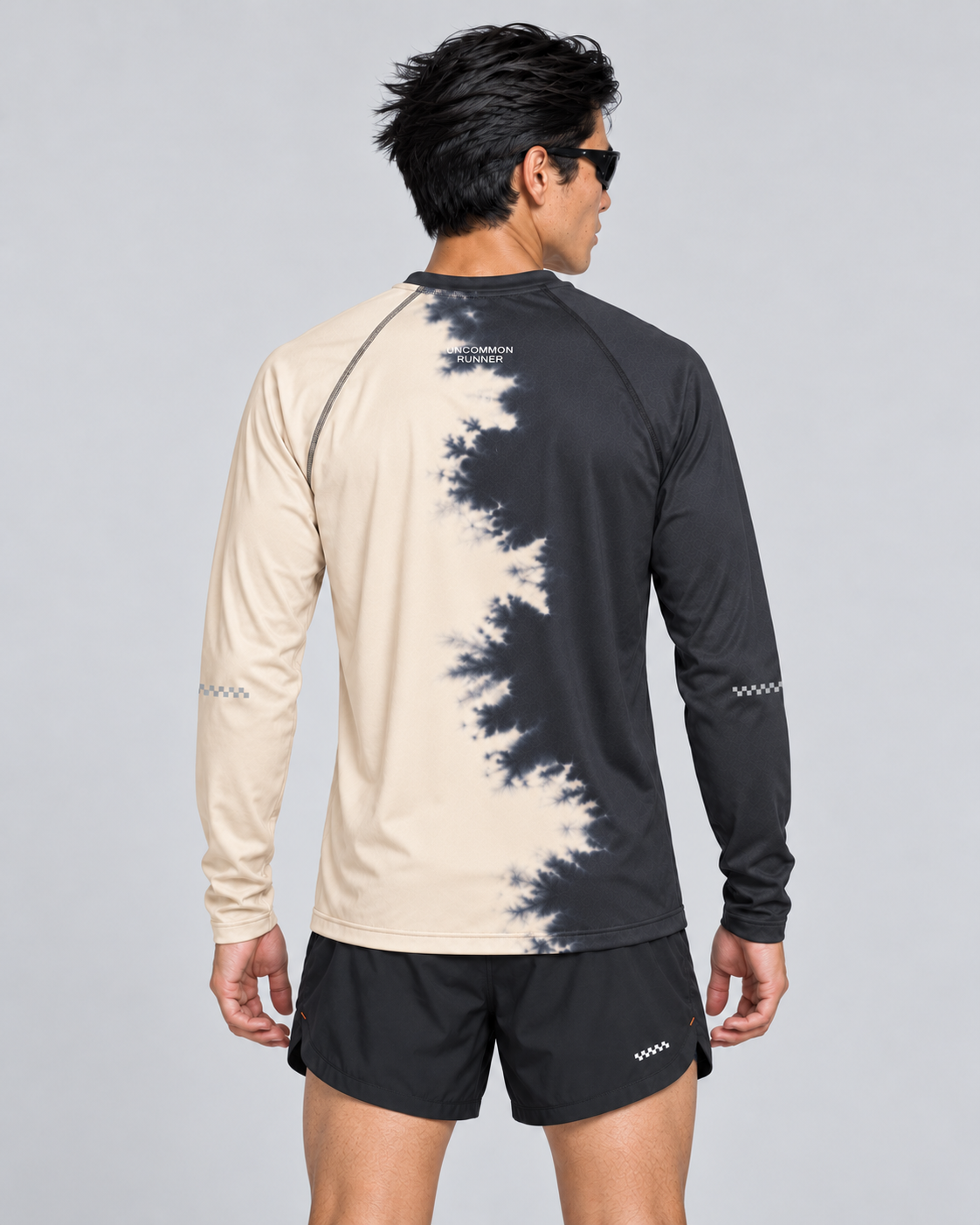 Back studio view of a male model wearing the Half Dye long-sleeve TempoTech running tee with upper-back wordmark and sleeve checker details