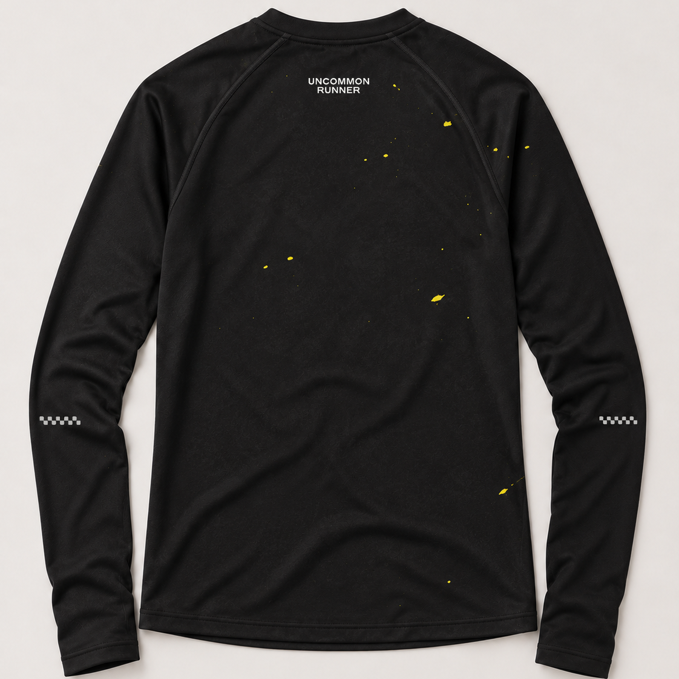 Back view of the Keep Running Weird long-sleeve TempoTech running tee in black with yellow splatter, white upper-back wordmark and sleeve checker details