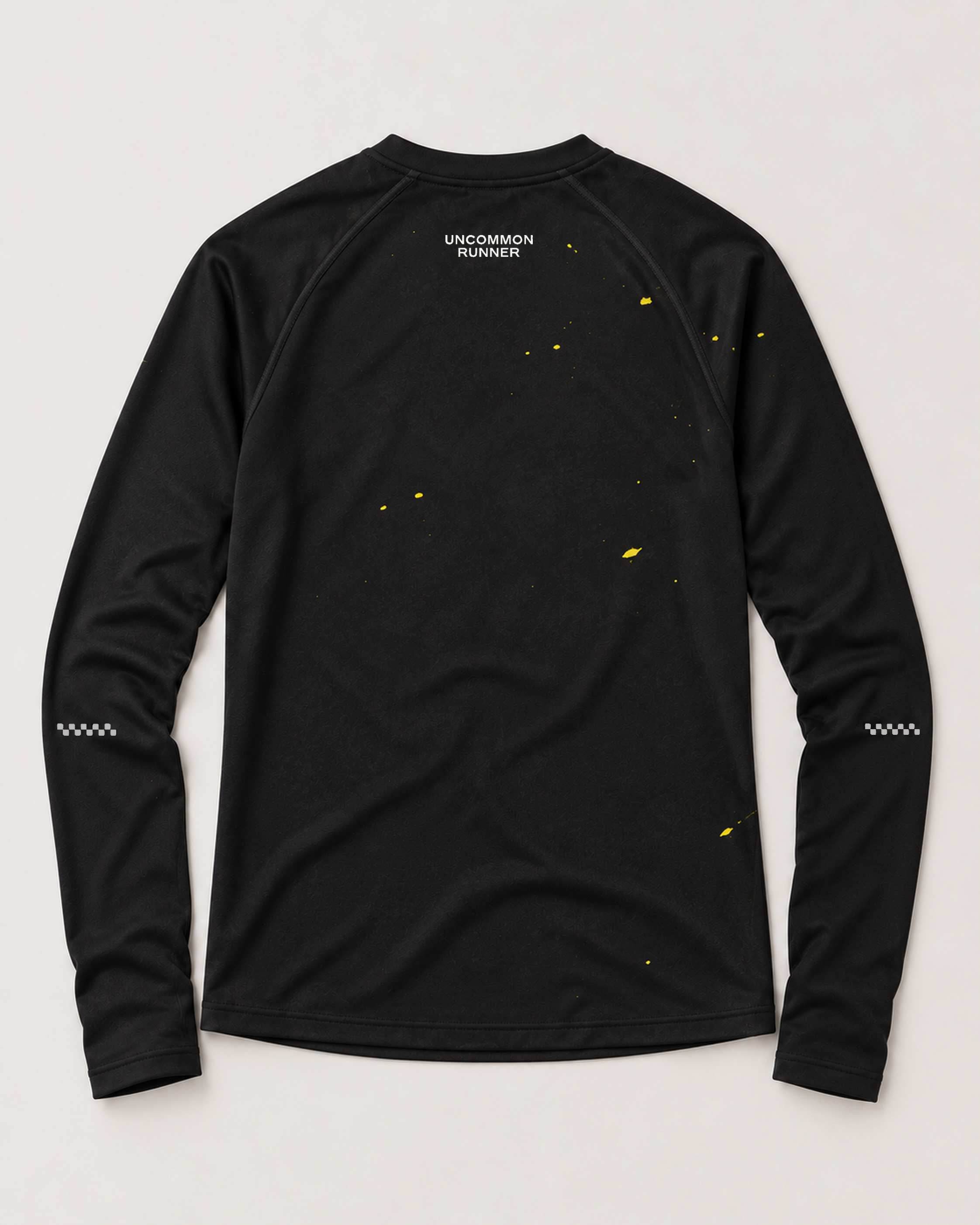 Back view of the Keep Running Weird long-sleeve TempoTech running tee in black with yellow splatter, white upper-back wordmark and sleeve checker details
