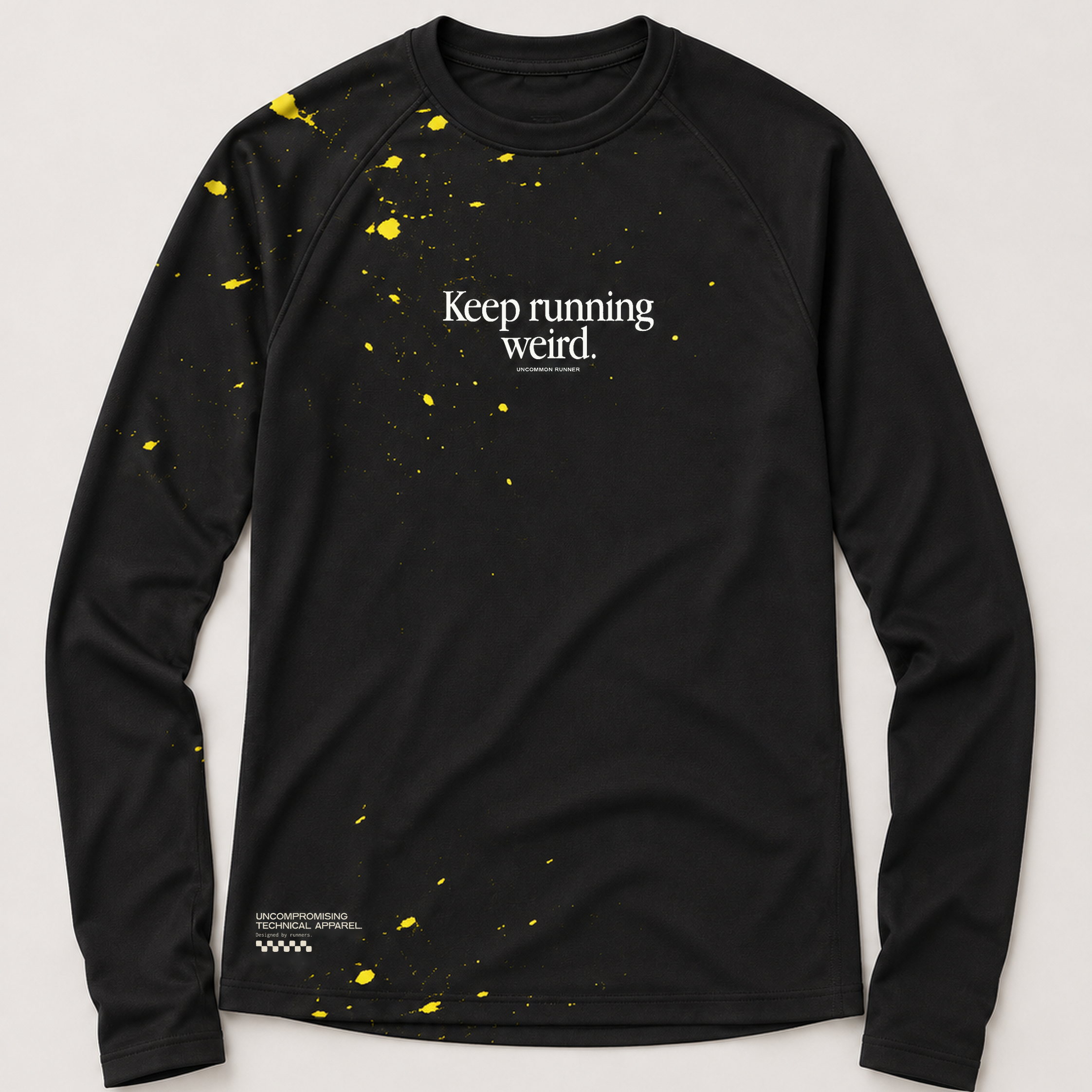 Front view of the Keep Running Weird long-sleeve TempoTech running tee in black with yellow splatter, white chest lettering and hem print