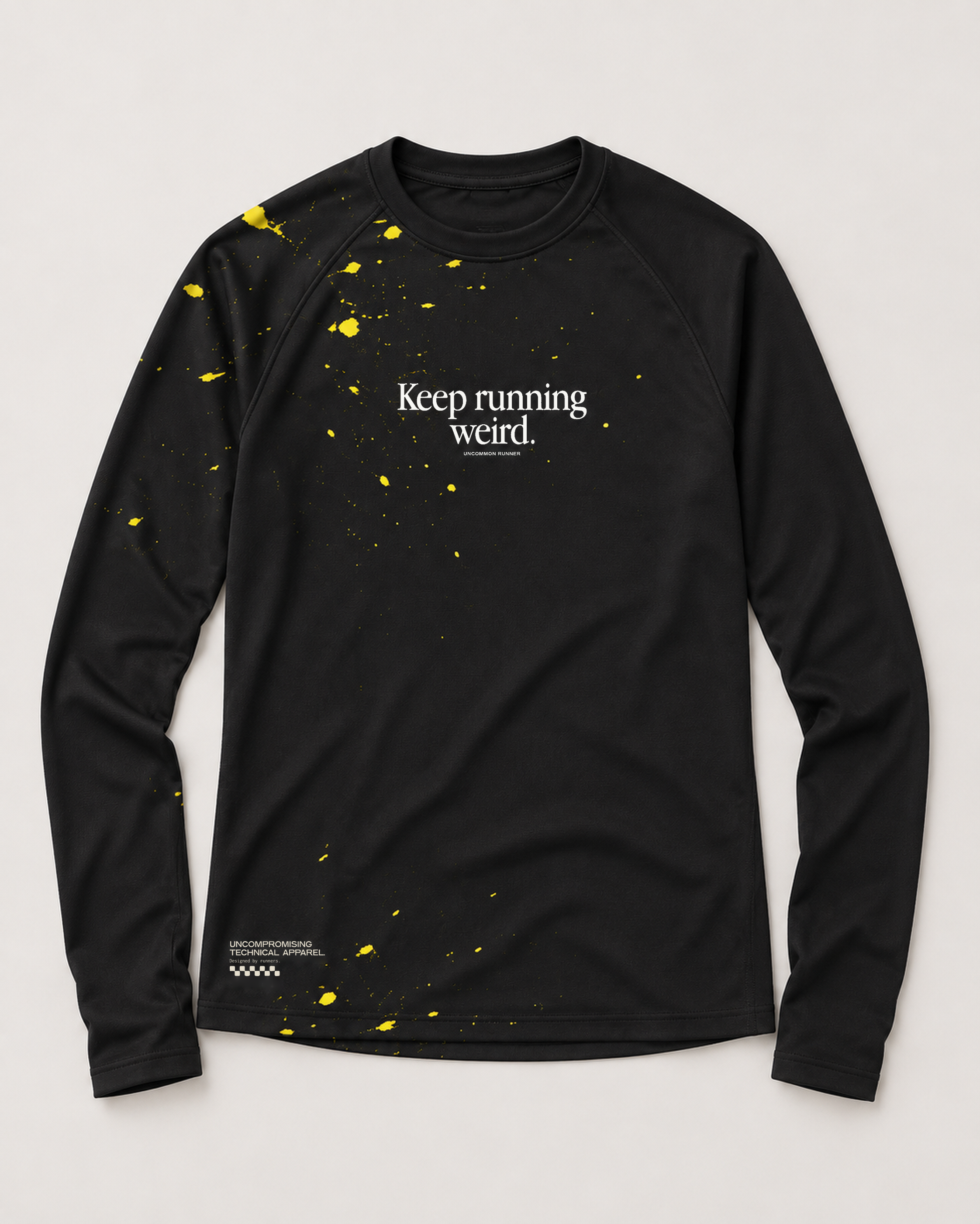 Front view of the Keep Running Weird long-sleeve TempoTech running tee in black with yellow splatter, white chest lettering and hem print